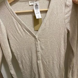 V-neck henley with long sleeves and shell buttons.